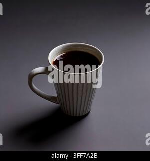 Café noir chaud dans une grande tasse en céramique cannelée sur un fond minimaliste sombre avec un éclairage dramatique Banque D'Images