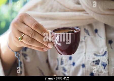 jeune femme tenant une tasse à café turque dans un cadre confortable Banque D'Images