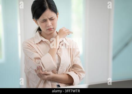 syndromes de bureau, femme massant des douleurs cervicales dues au travail et à l'aide d'un ordinateur, composite numérique d'une colonne vertébrale focalisée de douleurs cervicales et d'épaule symp Banque D'Images