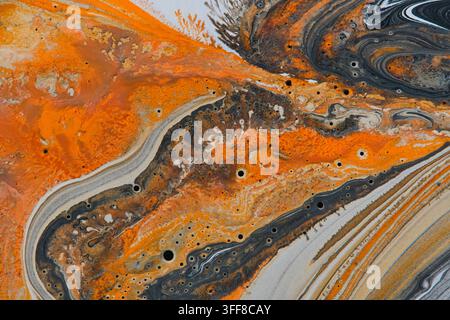 Fond d'art liquide abstrait vibrant avec des cellules et des tourbillons de peinture orange intense et gris foncé Banque D'Images