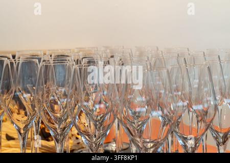 Verres à champagne vides disposés avec soin, reflétant une lumière dorée Banque D'Images