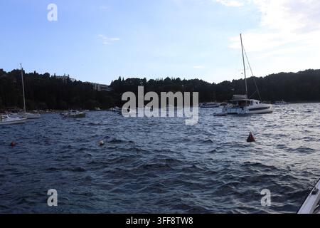 Paysage marin au niveau des yeux de bateaux amarrés et d'un catamaran dans des eaux agitées le long de la côte dalmate Banque D'Images