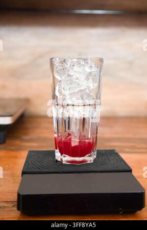 Sélection de boissons servies dans un café-bar, comprenant un verre de bière ambrée, un latte au matcha, un thé glacé et un verre en cours de préparation avec des glaçons. Banque D'Images