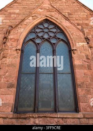 Grande fenêtre en arc pointu intégrée dans l'extérieur en grès rouge de la chapelle commémorative Evans sur le campus de l'Université de Denver à Denver, Colorado Banque D'Images
