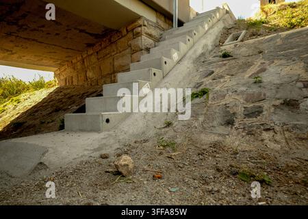 Nouvel escalier en béton et talus renforcé sous un pont dans un lit de rivière asséché Banque D'Images