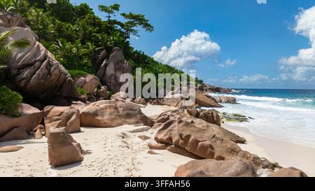 Vagues s'écrasant contre de gros rochers de granit sur la plage tropicale. La Digue, Seychelles. Banque D'Images