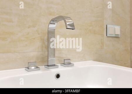 Robinet chrom dans la salle de bain de la copropriété Banque D'Images