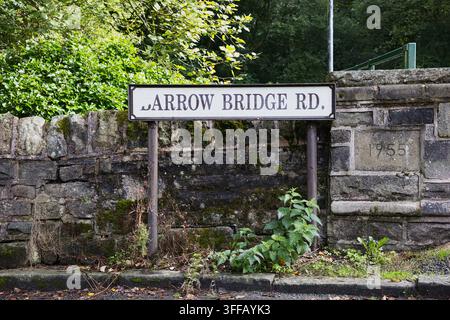 Plaque de nom de rue traditionnelle pour Barrow Bridge Rd montée sur un vieux mur de pierre avec une pierre datée de 1955 à Bolton, Greater Manchester, Lancashire, Royaume-Uni. Banque D'Images
