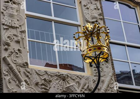 Zwolle, Pays-Bas : Gros plan d’une magnifique lampe de rue décorative en forme de couronne dorée fixée à la façade ornée d’un bâtiment historique. Banque D'Images