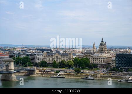 Vue panoramique de Budapest, Hongrie, à travers le Danube, mettant en vedette le Pont des Chaînes, la Basilique Saint-Étienne, l'architecture historique et la circulation urbaine Banque D'Images