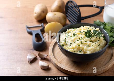 Purée de pommes de terre crémeuse avec persil frais sur une table en bois Banque D'Images
