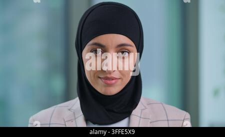 Portrait d'une femme d'affaires arabe heureuse en hijab travaillant au bureau, femme d'affaires musulmane travaillant dans une entreprise, cadre indienne confiante et calme, femme islamique Banque D'Images