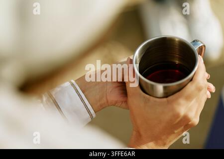 Femme tenant une tasse en métal avec du thé chaud pendant une pause en plein air Banque D'Images