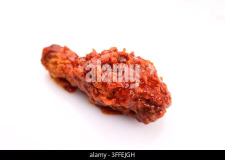Un poulet frit coréen épicé glacé à la sauce Gochujang, isolé sur fond blanc Banque D'Images