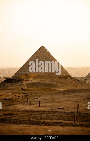 Les célèbres pyramides de Gizeh au Caire, en Égypte. Une tempête de sable donne à l'air une couleur orange. Belle scène de désert Banque D'Images