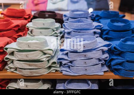 Chemises colorées à col pliées en piles soignées Banque D'Images