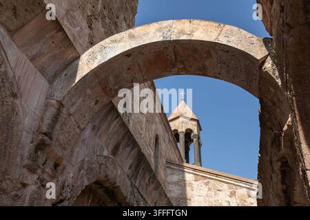Clocheton de monastère en pierre ancienne vu à travers des arches patinées. L'église d'Odzun est une basilique arménienne construite autour des Ve–VIIe siècles Banque D'Images