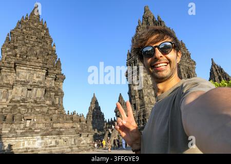 Portrait rapproché d'un homme joyeux prenant un selfie avec un fond du temple de Prambanan Banque D'Images