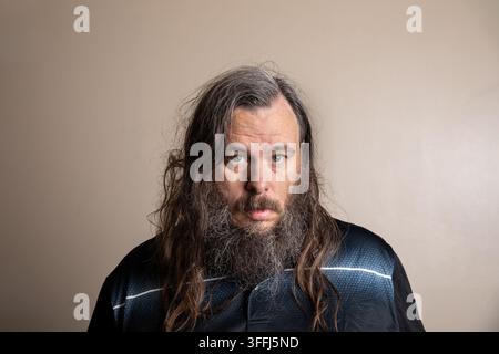 Portrait d'un homme aux cheveux longs et ondulés et à la barbe fournie Banque D'Images