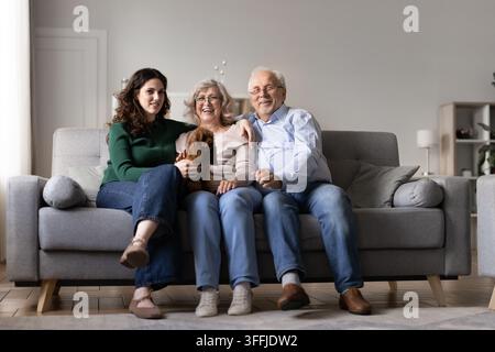 Petite-fille heureuse et grands-parents seniors posant pour un portrait familial multi-générationnel Banque D'Images