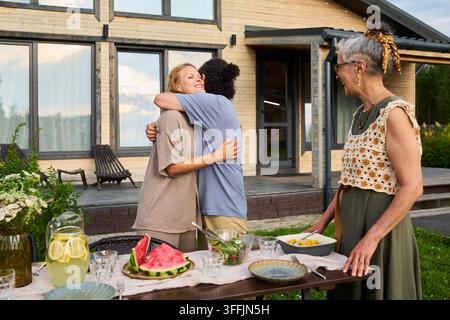 Mari et femme s'embrassant et se saluant lors d'un dîner en plein air Banque D'Images