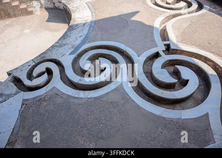 Un motif en spirale artistique gravé dans le sol en pierre, mettant en valeur un artisanat complexe, palais de Jahaz Mahal, Inde Banque D'Images