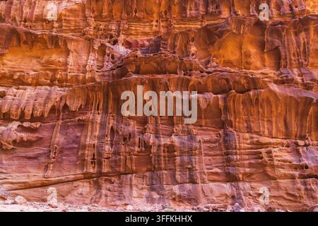 Vue de la zone protégée de Wadi Rum présentant des falaises de grès rouge imposantes avec des motifs d’érosion complexes et une lumière chaude du désert dans le village de Wadi Rum, Aqa Banque D'Images
