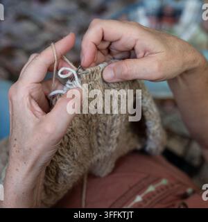 Grossissement des mains tricotant à la main un tissu de laine texturé Banque D'Images