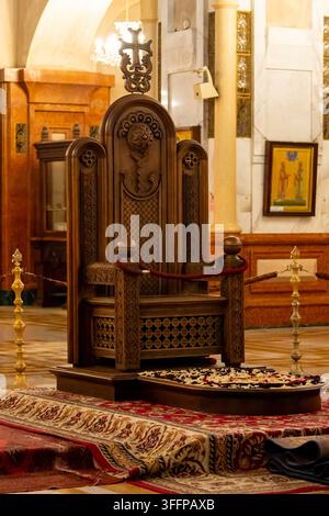 Un trône en bois richement décoré, présentant des sculptures détaillées et une croix proéminente, se dresse dans un cadre sacré d'église. Cathédrale de la Sainte Trinité, Sa Banque D'Images