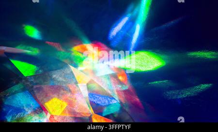 Composition abstraite vibrante de lumière multicolore se réfractant à travers un prisme cristallin à facettes, créant des formes géométriques lumineuses, des réflexions arc-en-ciel Banque D'Images