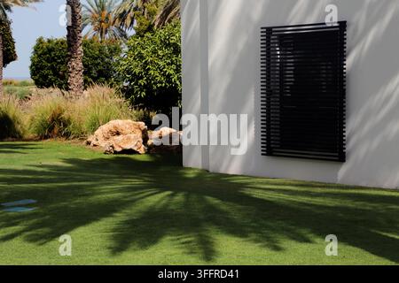 Ombre d’un palmier dattier sur l’herbe dans le jardin du The Chedi Hotel Muscat au Sultanat de Oman Banque D'Images