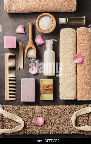 Mise à plat de la composition de certains accessoires de salle de bain sur un fond rustique brun foncé. Vue de dessus Banque D'Images