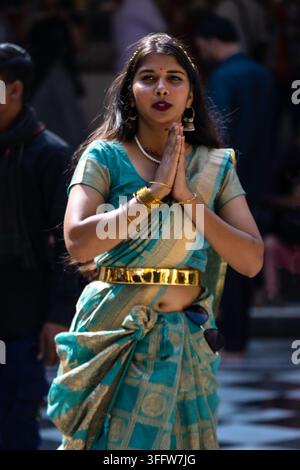 Jeune femme indienne priant dans un sari traditionnel Banque D'Images