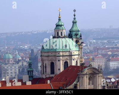 Vue de l'église baroque Saint-Nicolas et du clocher au-dessus des toits historiques de Malá Strana à Prague, République tchèque. Banque D'Images