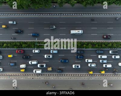 Vue aérienne d'un trafic intense sur une autoroute à plusieurs voies avec diverses voitures, fourgonnettes et motos circulant sur la route entourée d'arbres verts à Gurga Banque D'Images