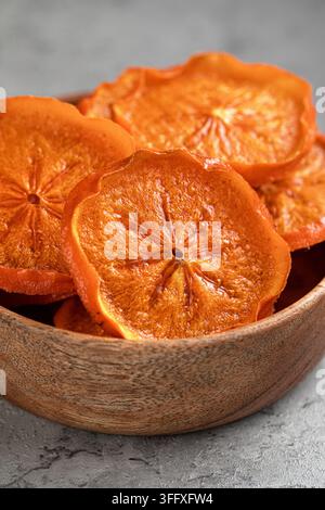 Tranches d'orange séchées dans un bol en bois sur de la pierre Banque D'Images