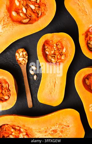 Demi-tas de courge butternut disposées en flat lay décoratif avec des couleurs chaudes. Composition de récolte saisonnière avec citrouille et présentation rustique Banque D'Images