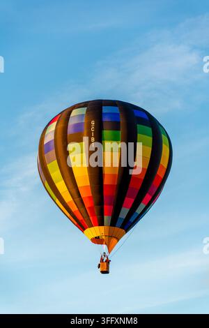 Bakewell, Royaume-Uni - 05 septembre 2026 : Vue d'un ballon à air chaud coloré flottant dans le ciel bleu clair. Banque D'Images