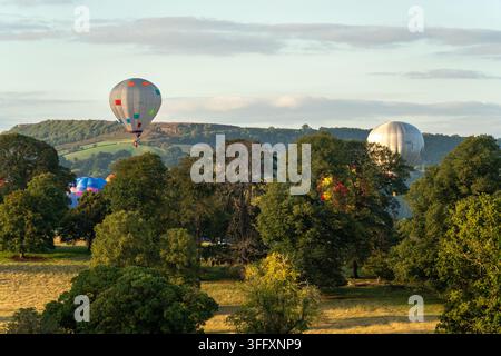 Bakewell, Royaume-Uni - 05 septembre 2026 : Vue des montgolfières flottant au-dessus des parcs de Chatsworth House avec des arbres verts luxuriants et des collines ondulantes Banque D'Images