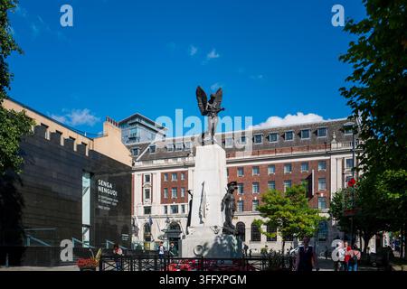 La figure ailée de la Victoire du Leeds War Memorial se dresse devant la Leeds Art Gallery, avec un bâtiment d'hôtel en arrière-plan, Leeds, Angleterre, Royaume-Uni Banque D'Images