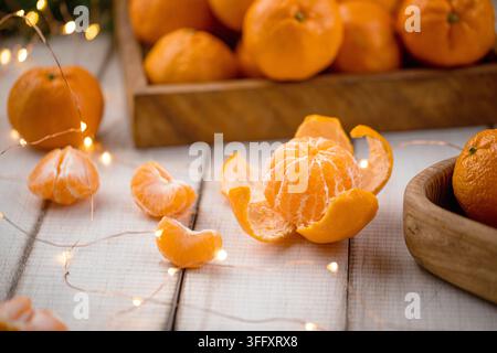 Mandarines pelées avec des lumières de Noël Banque D'Images