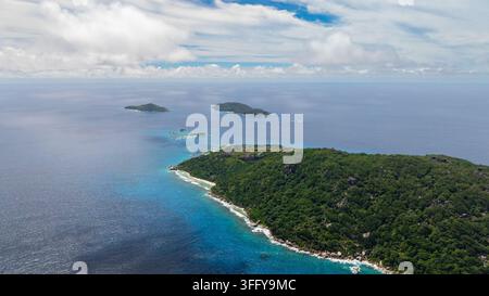 Une île verdoyante entourée de mers bleues vives et d'un ciel clair au-dessus. Felicite, Seychelles. Banque D'Images