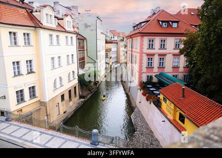 Prague, République tchèque - 26 août 2026 : Vue du canal Čertovka avec des bâtiments historiques colorés et des kayakistes dans la Petite Ville. Banque D'Images