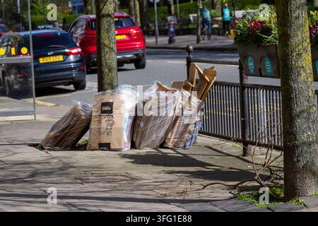 Des piles de déchets de carton commerciaux de Biffa sont empilées sur le trottoir près d'un arrêt de bus dans une rue publique. Southport, Royaume-Uni. Banque D'Images