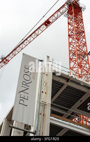 Chantier de construction avec une grue rouge et un bâtiment à plusieurs étages, ciel nuageux, chantier de construction du bâtiment administratif de Penrose Dock à Cork City, Irlande Banque D'Images