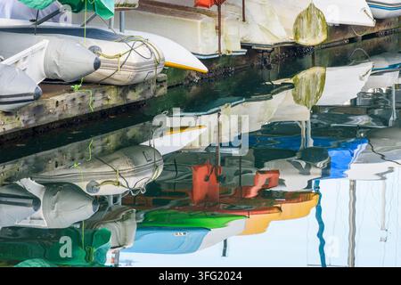 Les dinghies stockés pour l'hiver sur un quai créent un reflet coloré dans le False Creek, Vancouver, Colombie-Britannique Banque D'Images