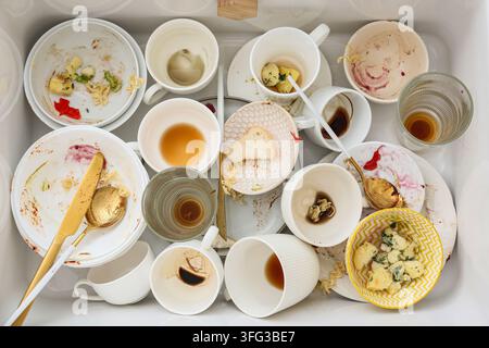 Tâches ménagères et désordre domestique, vaisselle sale et restes de nourriture dans l'évier de la cuisine après une soirée ou un repas familial avec une vaisselle en désordre Banque D'Images