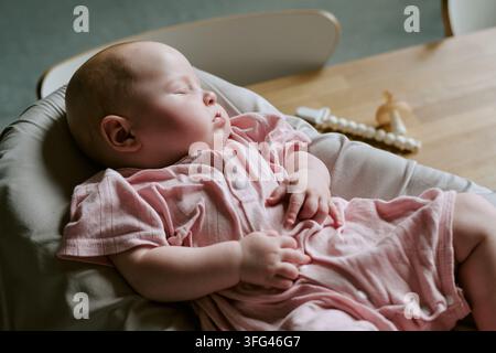 Bébé fille dormant paisiblement dans une chaise à bascule à la maison Banque D'Images