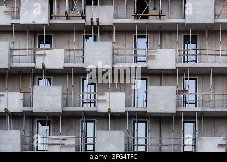 architecture moderne bâtiment résidentiel en construction façade avec béton brut balcons géométriques supports d'échafaudage en acier rampe de sécurité en bois Banque D'Images