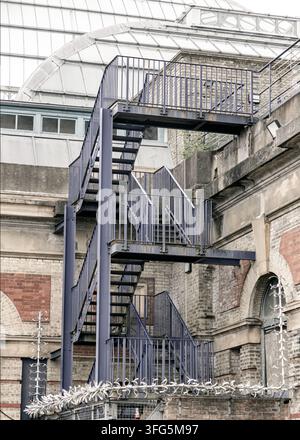 Londres, Royaume-Uni - 09 juin 2025 - Ancré contre la façade érodée de l’Alexandra Palace, un escalier industriel en métal frappant, peint d’un violet profond Banque D'Images